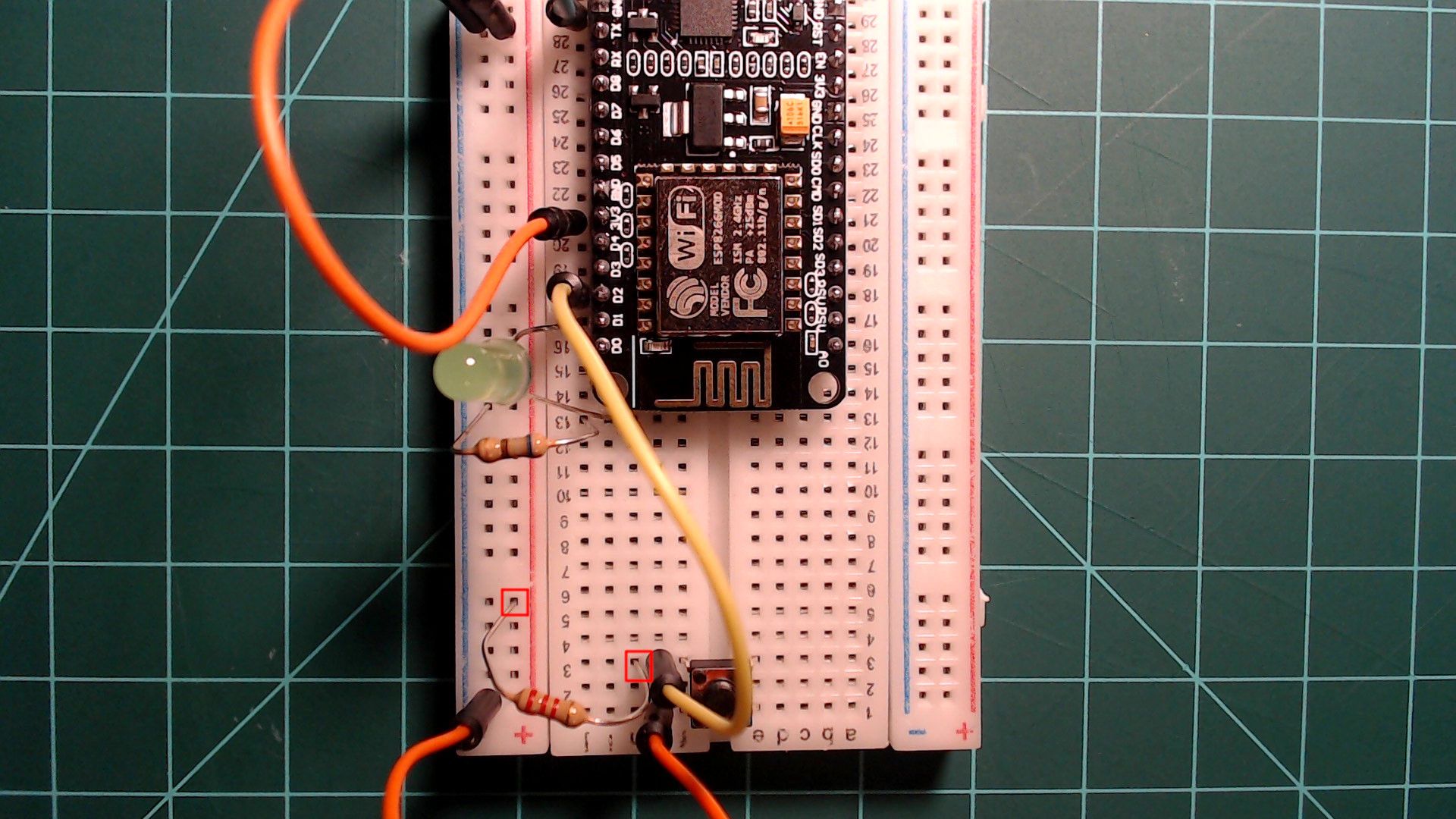 The button circuit with a resistor added from the button's D2 side to the 3.3V rail, both ends outlined in red; the yellow D2 wire and the orange ground wire are still in place.