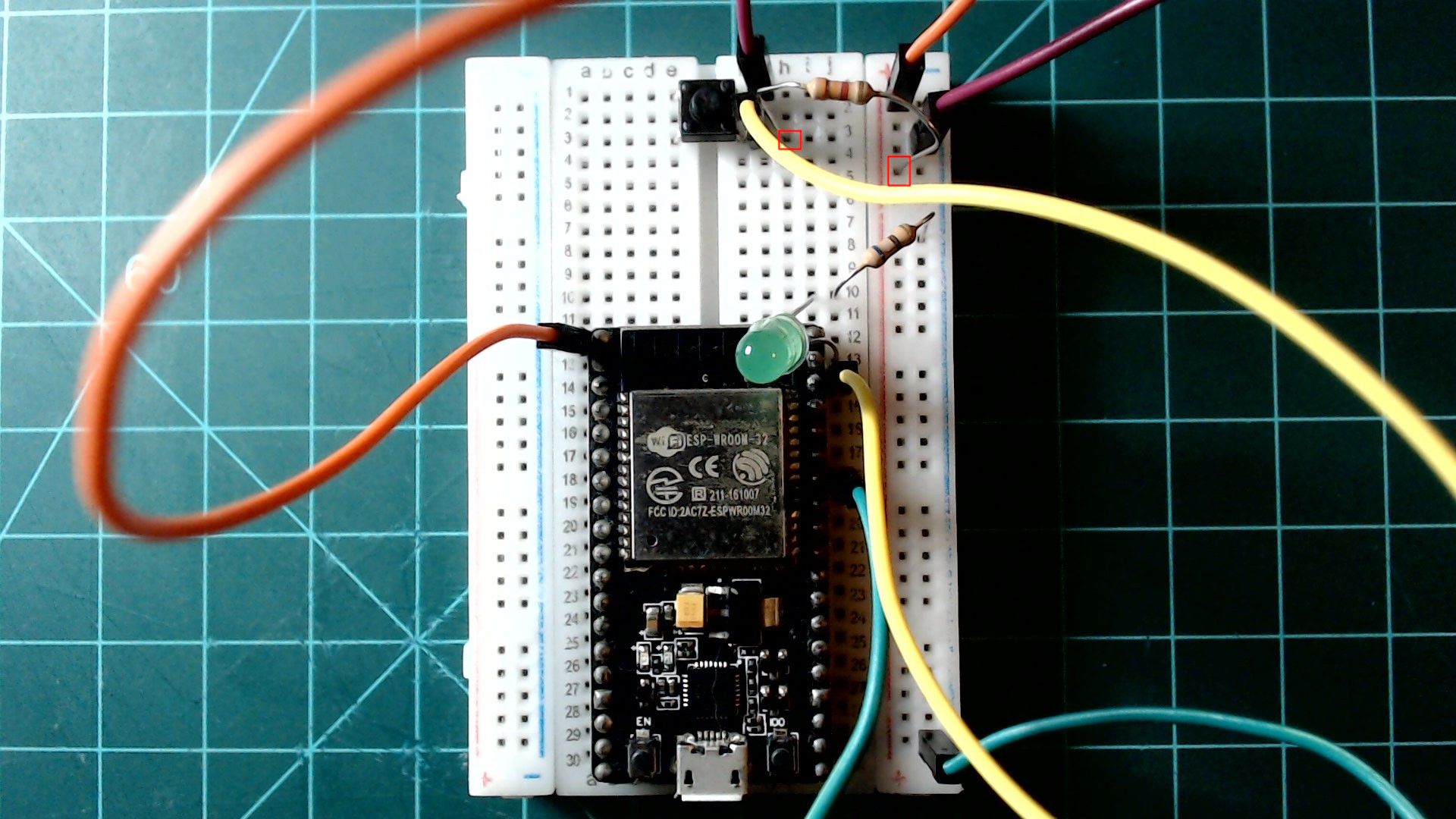 The ESP32 button circuit with a resistor added from the button's GPIO22 side to the 3.3V rail on the right, both ends outlined in red.