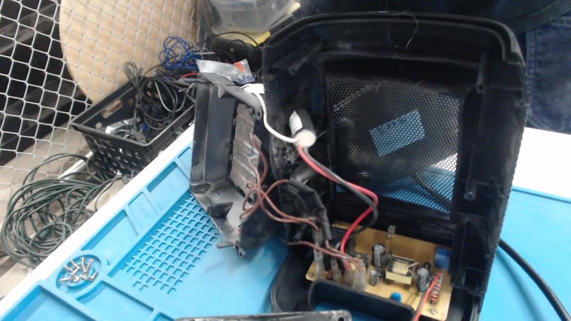 The open enclosure with the fan gone and the heating element tilted out to the left on its brown wires. Below it, the circuit board is now in view, with red, black and brown wires plugged into it.
