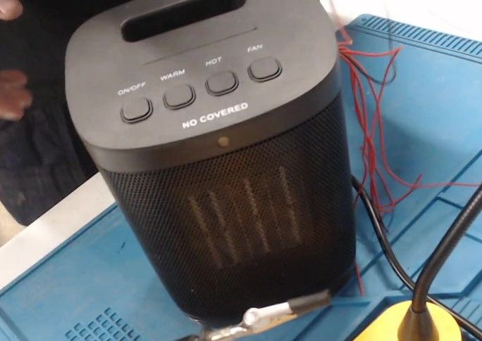 The heater closed up again on the work mat, with a bundle of red wires leading out from behind it.